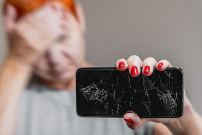 Cropped hand of woman using mobile phone