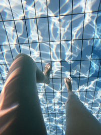 Legs of a young woman with reflexions underwater in a pool underwater photography