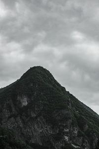 Low angle view of rocky mountain against sky