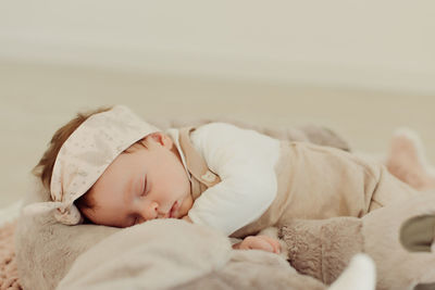 Cute baby girl sleeping on bed at home