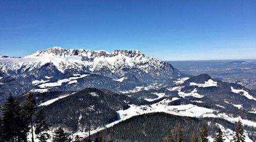 Scenic view of snowcapped mountains against clear blue sky