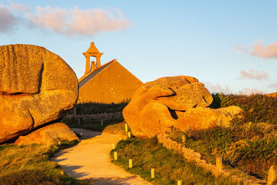 View of rocks on landscape against sky