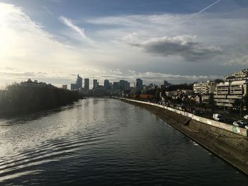 River amidst buildings in city against sky