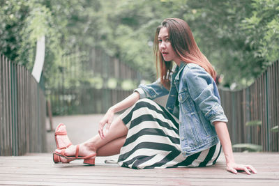 Full length of woman sitting outdoors