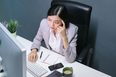 Man using mobile phone while sitting on table