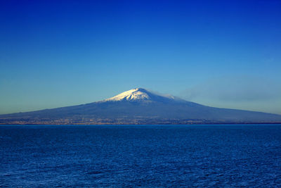Scenic view of snowcapped mountains against clear blue sky