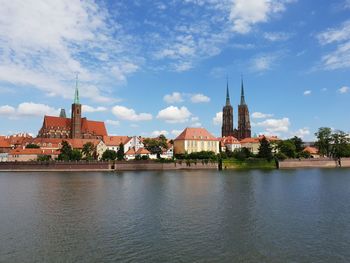 View of buildings at waterfront against cloudy sky