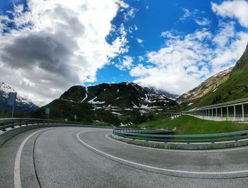 Road by mountain against sky