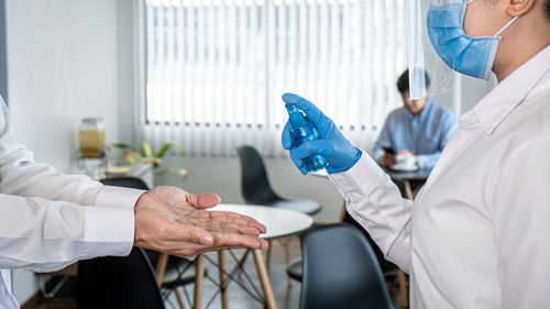 Midsection of doctor examining patient in laboratory