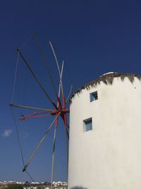 Low angle view of windmill against clear blue sky