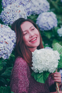 Portrait of a beautiful young woman holding flower bouquet