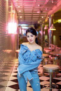 Portrait of young woman standing in corridor