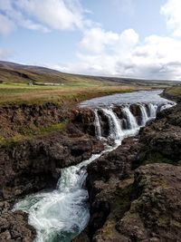 Scenic view of waterfall against sky