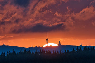Silhouette of communications tower during sunset