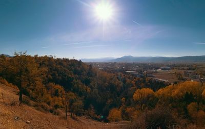 Scenic view of landscape and autumn trees against sky