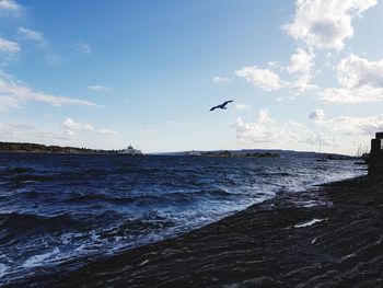 Seagulls flying over sea against sky