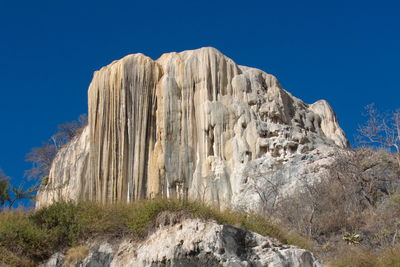 Low angle view of mountain against clear blue sky