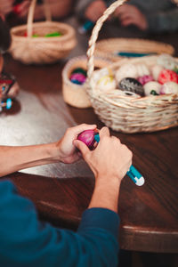 High angle view of woman holding basket on table