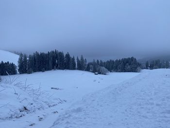 Scenic view of snow covered field against sky