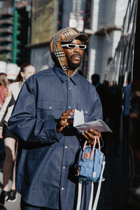 Man with umbrella standing in city