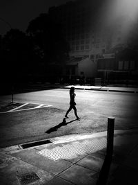 Silhouette man on road in city