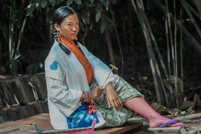 Woman looking away while sitting outdoors