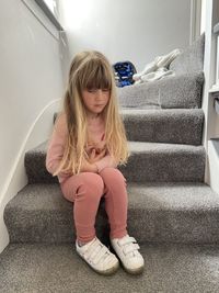 Full length of girl sitting at home