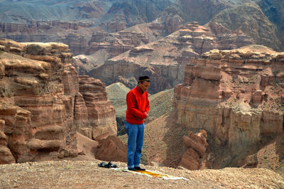 View of man praying in canyon