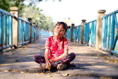 Portrait of smiling girl sitting on tree