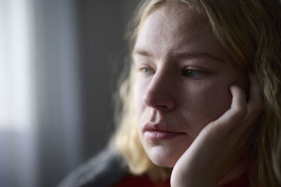 Pensive teenage girl with hand on chin