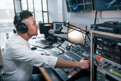 Setting the equipment. young man is indoors in the radio studio is busy by broadcast.