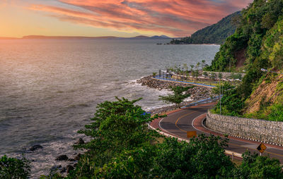 High angle view of road by sea against sky during sunset