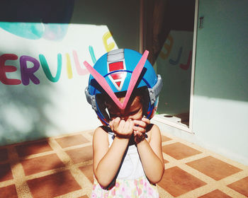 Close-up of cute girl wearing helmet while standing at yard