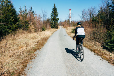 Full length of woman riding bicycle in forest