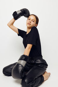 Portrait of young woman exercising against white background