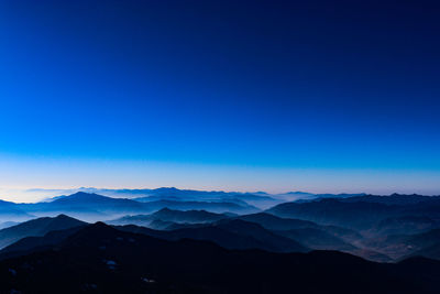 Scenic view of silhouette mountains against clear blue sky