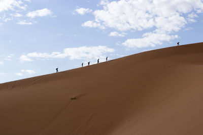 Low angle view of sand dunes against sky