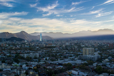 Aerial view of city against cloudy sky