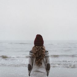 Rear view of woman looking at sea against sky