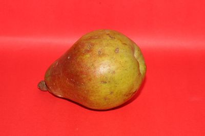 Close-up of apple against red background