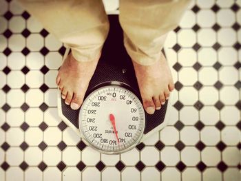 Low section of man standing on tiled floor
