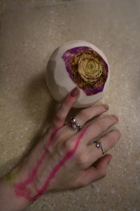 High angle view of woman hand holding pink flower