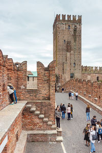 People at historical building against sky