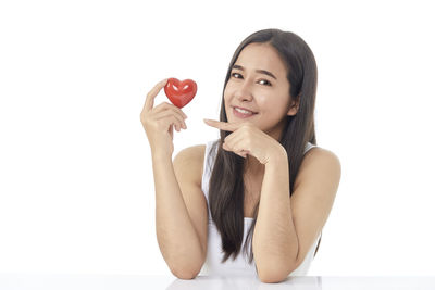 Portrait of a smiling young woman against white background