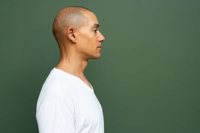 Side view of man standing against wall