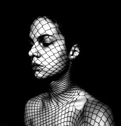 Portrait of woman against black background