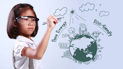 Digital composite image of girl drawing over earth against white background