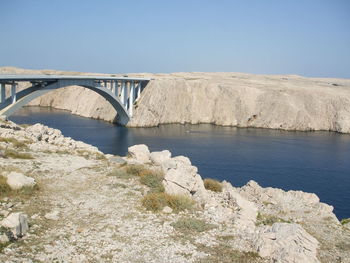 Arch bridge over river against clear sky