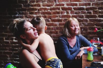 Portrait of friends sitting against wall