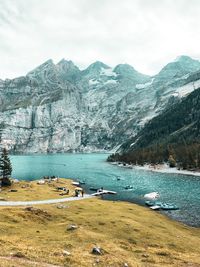 Scenic view of lake by mountains against sky